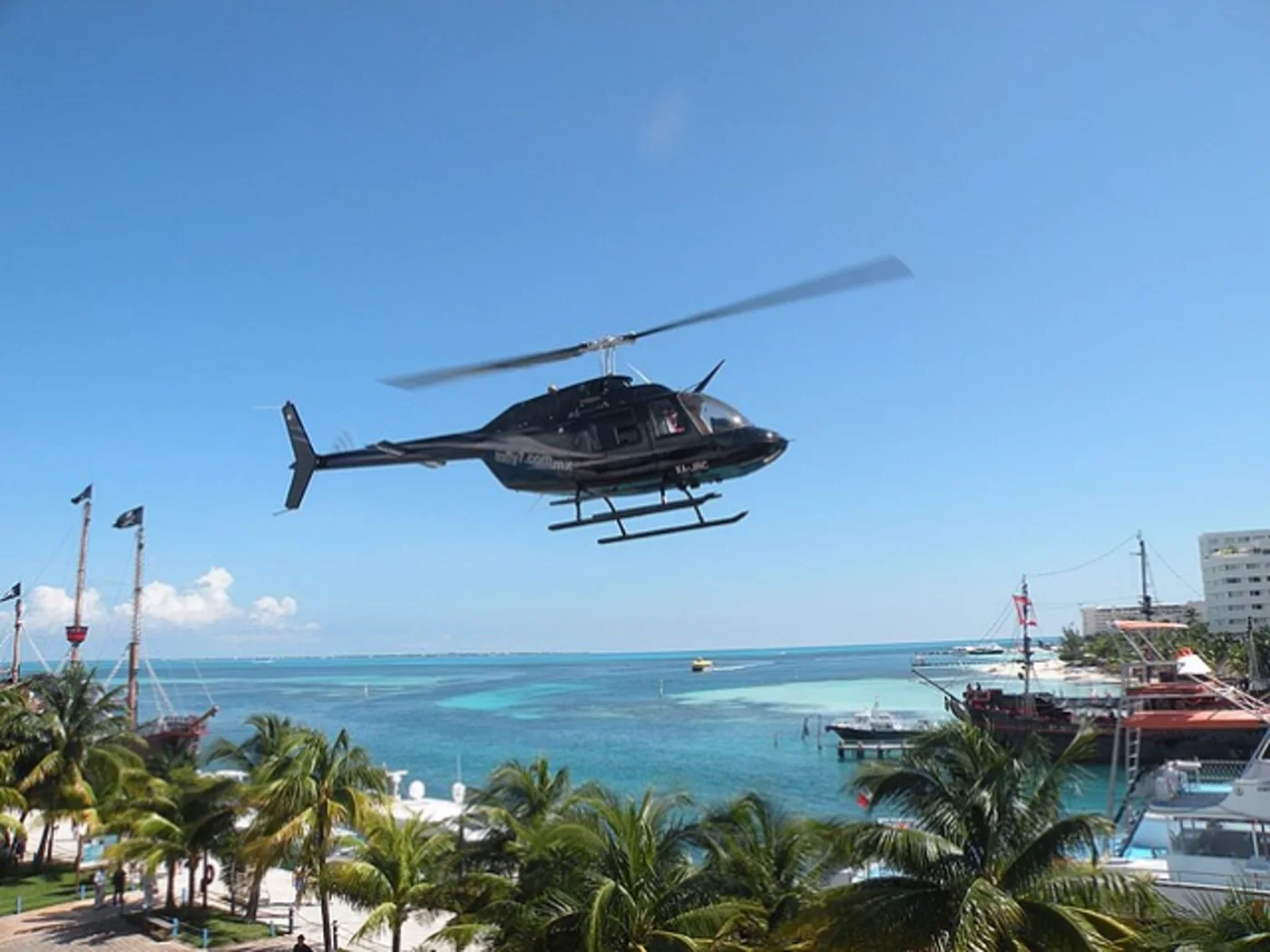 Helicopter flying over the turquoise Caribbean coastline